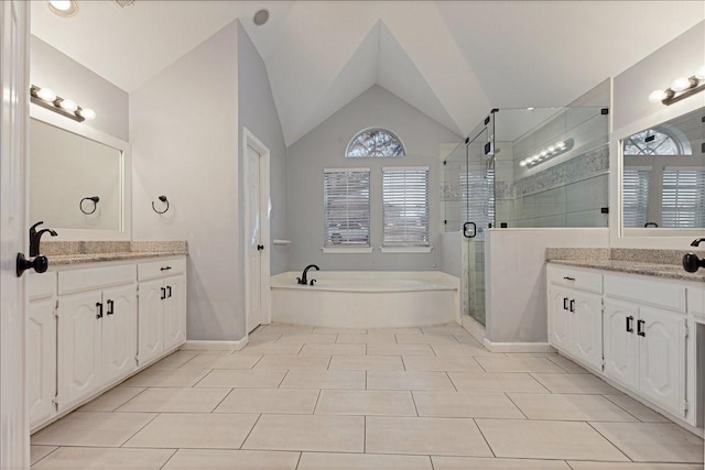 bathroom with lofted ceiling, two vanities, a shower stall, a garden tub, and tile patterned floors