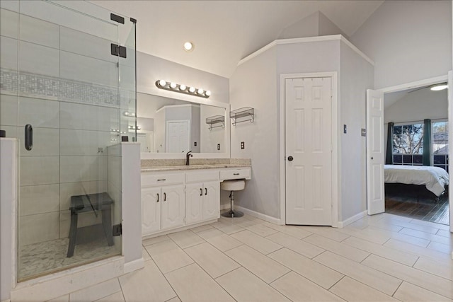 full bathroom with a stall shower, ensuite bath, baseboards, vanity, and vaulted ceiling