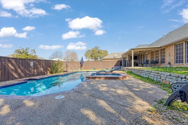 view of swimming pool featuring a fenced backyard, a pool with connected hot tub, and a patio