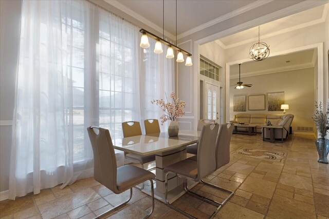 dining area with a wealth of natural light, visible vents, stone tile floors, and crown molding