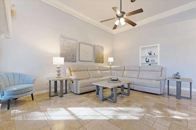 living room featuring built in features, baseboards, ceiling fan, and crown molding