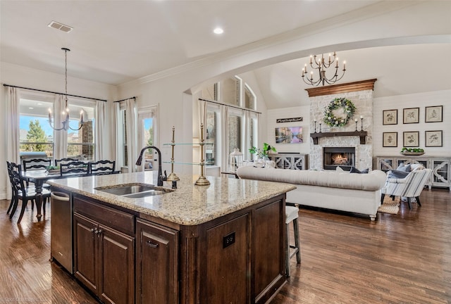 kitchen featuring visible vents, arched walkways, a sink, dark wood-type flooring, and a notable chandelier