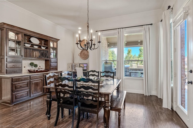 dining room with dark wood finished floors, an inviting chandelier, and ornamental molding