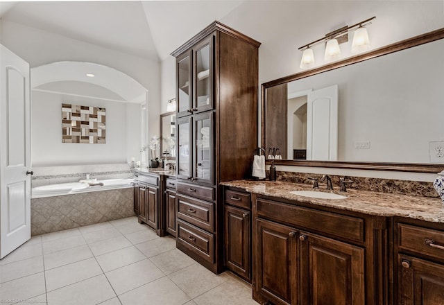 full bathroom with tile patterned floors, lofted ceiling, a bath, and vanity