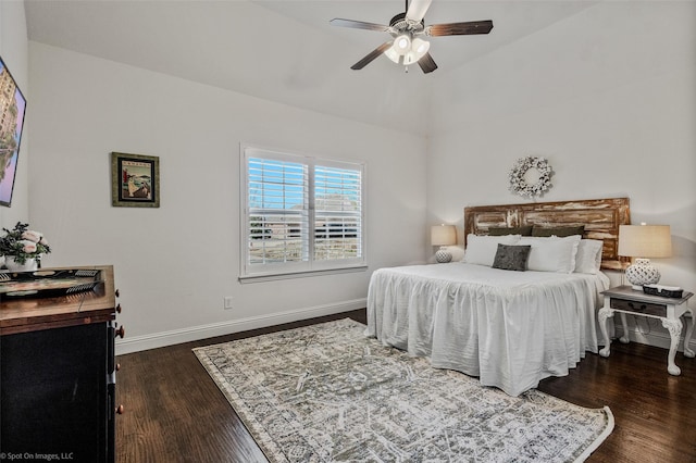 bedroom with a ceiling fan, vaulted ceiling, wood finished floors, and baseboards