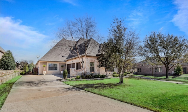 view of front of home with a front lawn, driveway, stone siding, fence, and a garage