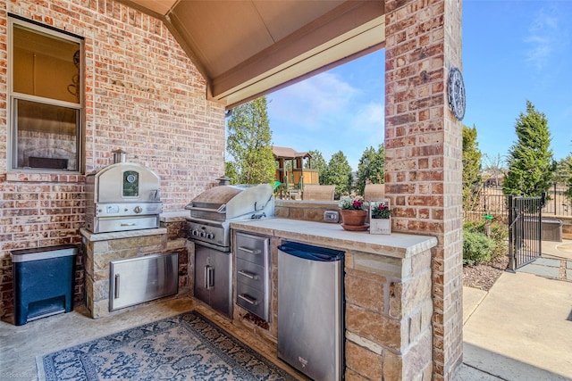 view of patio featuring an outdoor kitchen, a grill, and fence