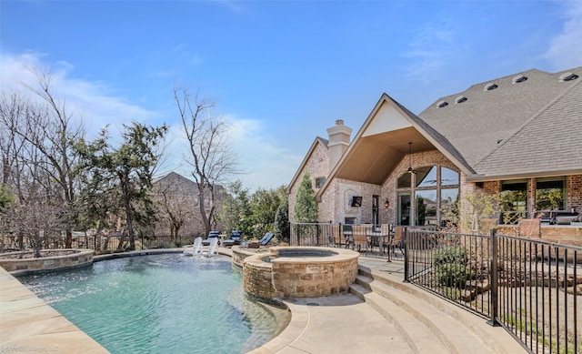 view of swimming pool with a patio, a pool with connected hot tub, and fence