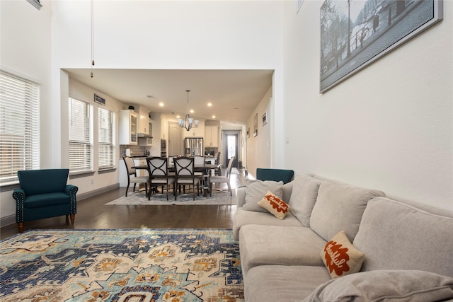 living room with recessed lighting, baseboards, dark wood-type flooring, and a high ceiling