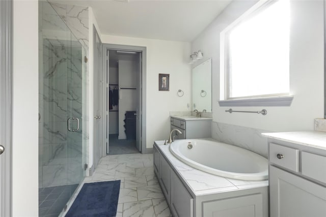 full bath featuring a marble finish shower, a walk in closet, a garden tub, marble finish floor, and vanity