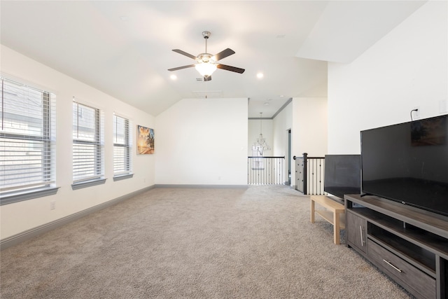 living room with light colored carpet, baseboards, ceiling fan, and vaulted ceiling