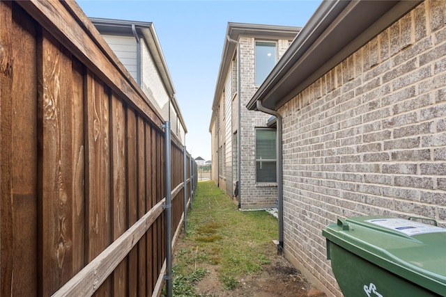 view of side of home featuring a yard and brick siding