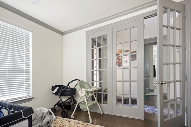 interior space featuring visible vents, baseboards, ornamental molding, french doors, and wood finished floors