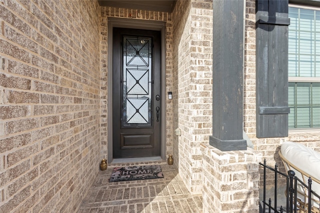 property entrance featuring brick siding