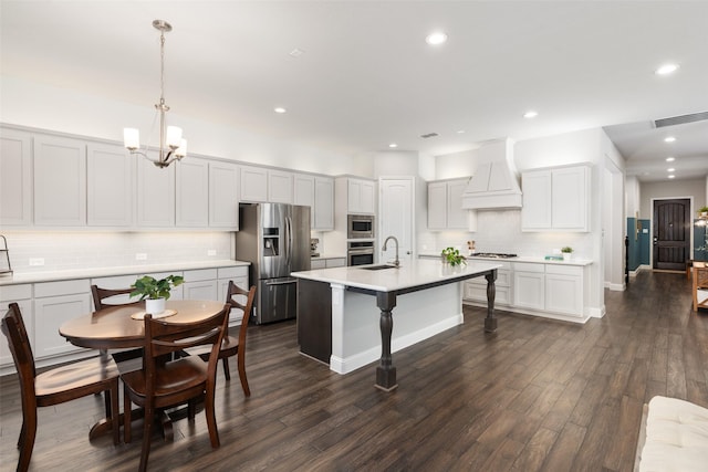 kitchen with visible vents, dark wood-type flooring, a sink, stainless steel appliances, and custom exhaust hood