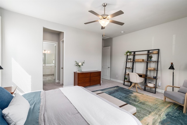 bedroom featuring light colored carpet, connected bathroom, baseboards, and ceiling fan