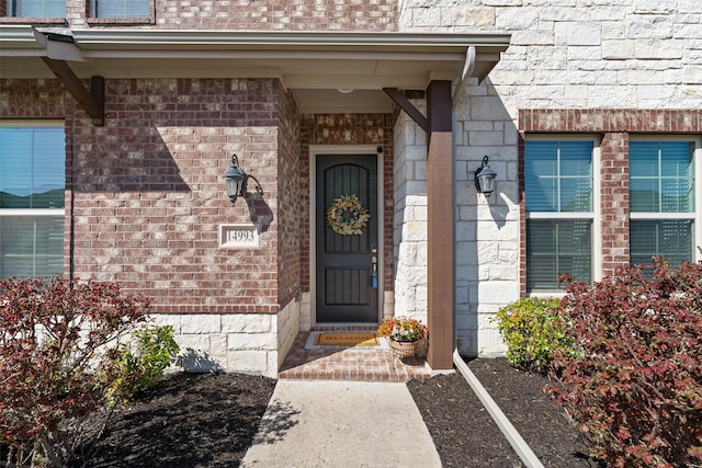 doorway to property featuring brick siding