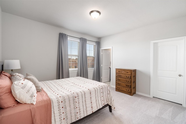 bedroom featuring light colored carpet and baseboards