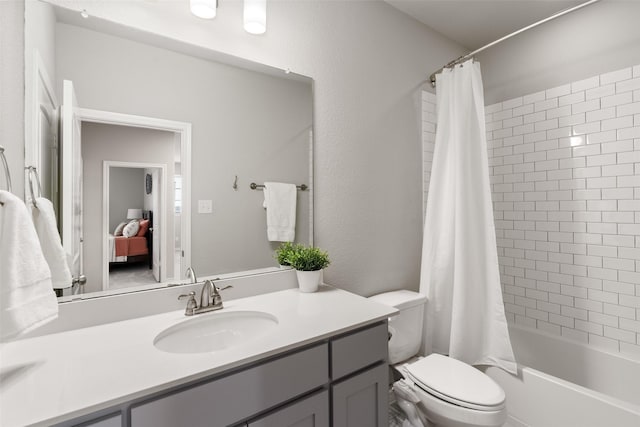 full bath featuring toilet, shower / bath combo, vanity, and a textured wall