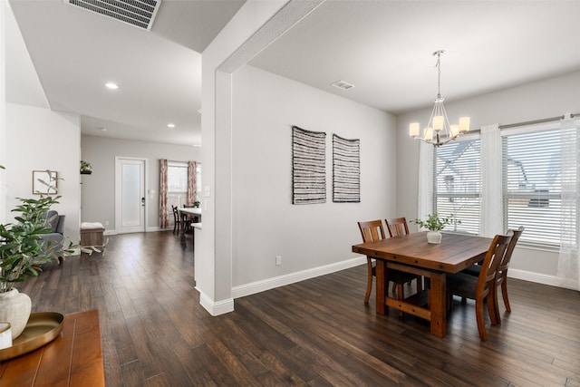 dining room with dark wood finished floors, baseboards, visible vents, and a chandelier