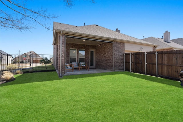 back of house featuring a patio area, a lawn, and a fenced backyard