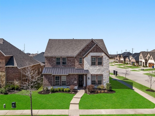 view of front of property with a standing seam roof, stone siding, a residential view, a front yard, and metal roof