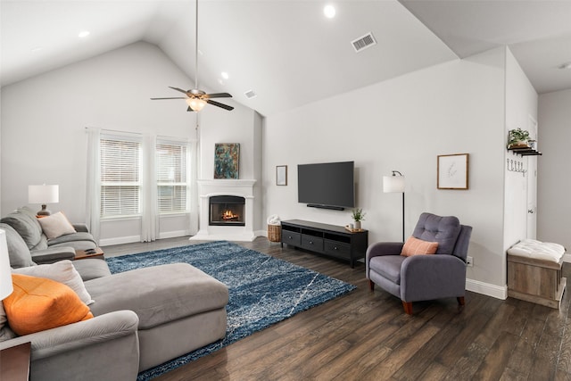 living area featuring ceiling fan, visible vents, a lit fireplace, and wood finished floors