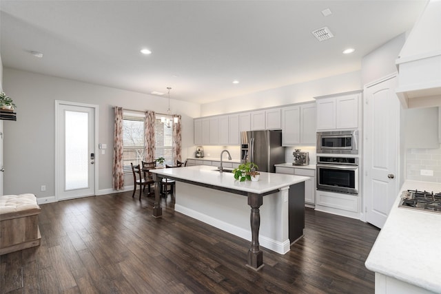 kitchen with visible vents, stainless steel appliances, light countertops, custom exhaust hood, and dark wood-style flooring