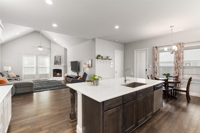 kitchen with a sink, dark wood finished floors, dark brown cabinetry, light countertops, and dishwasher