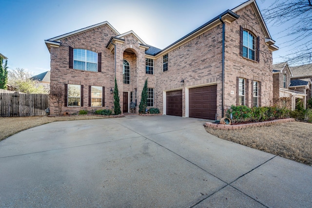 view of front of property with brick siding, an attached garage, concrete driveway, and fence