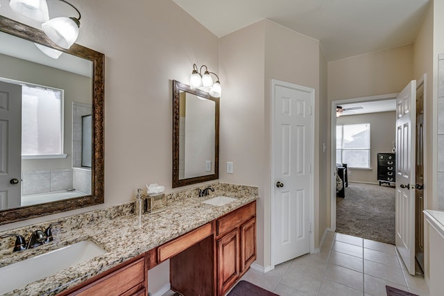 ensuite bathroom with tile patterned flooring, double vanity, baseboards, and a sink