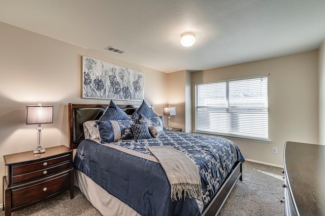 bedroom with baseboards, carpet, visible vents, and a textured ceiling