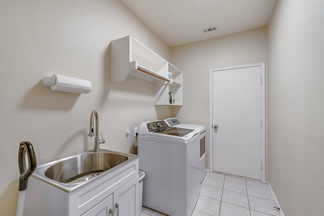 washroom featuring light tile patterned floors, visible vents, cabinet space, a sink, and independent washer and dryer