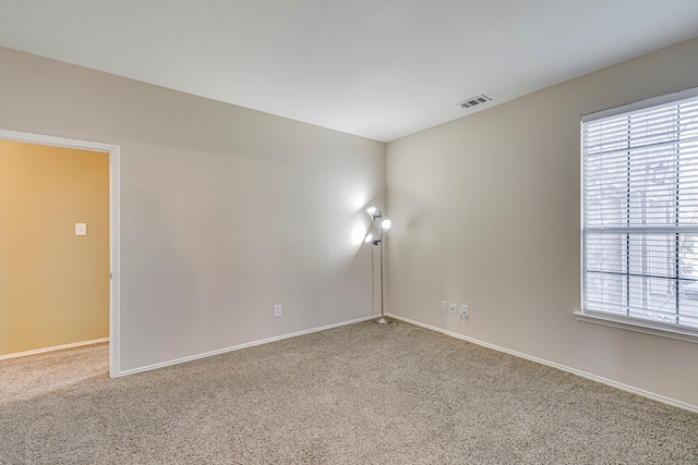 carpeted empty room featuring visible vents and baseboards