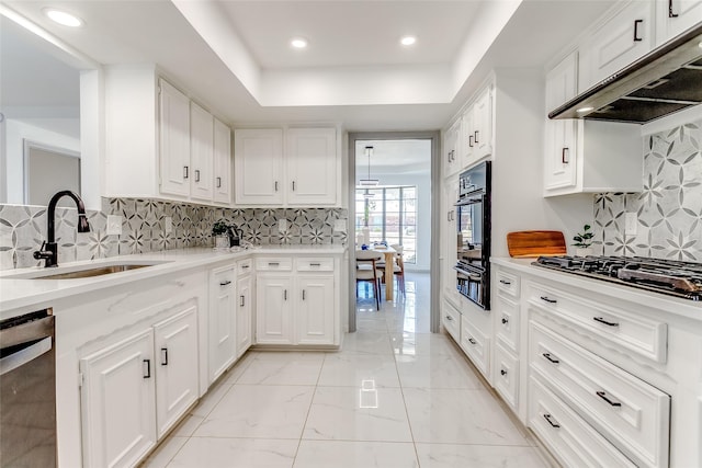 kitchen featuring marble finish floor, under cabinet range hood, a sink, gas stovetop, and dishwasher