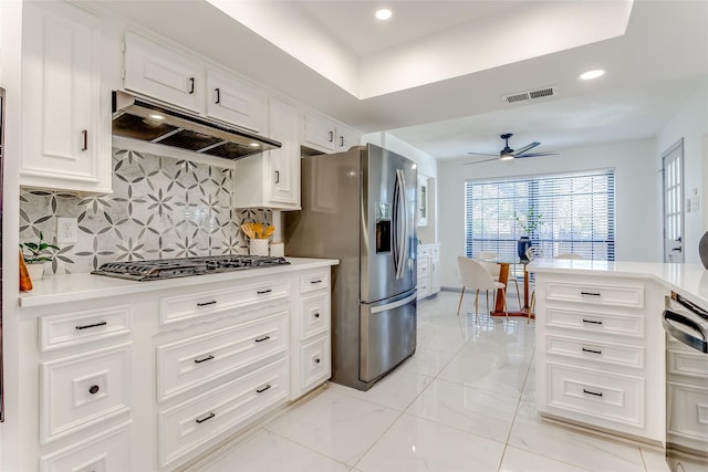 kitchen featuring visible vents, under cabinet range hood, backsplash, appliances with stainless steel finishes, and ceiling fan