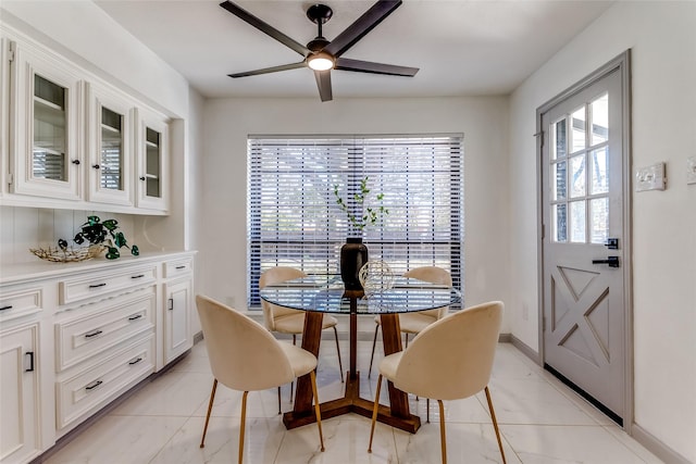 dining space with baseboards and a ceiling fan