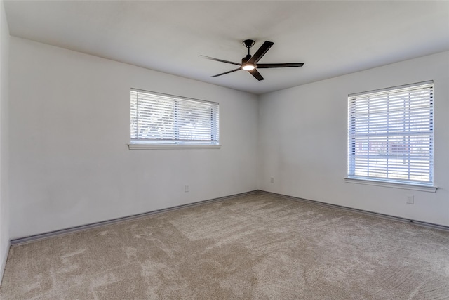 unfurnished room featuring plenty of natural light, carpet flooring, and a ceiling fan