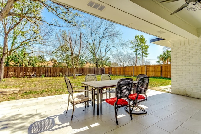 view of patio with visible vents, a ceiling fan, outdoor dining area, and a fenced backyard