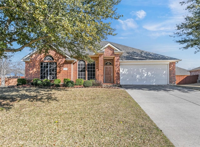 ranch-style house featuring fence, an attached garage, concrete driveway, a front lawn, and brick siding