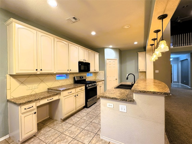 kitchen with visible vents, black microwave, stainless steel range with gas stovetop, decorative backsplash, and a sink