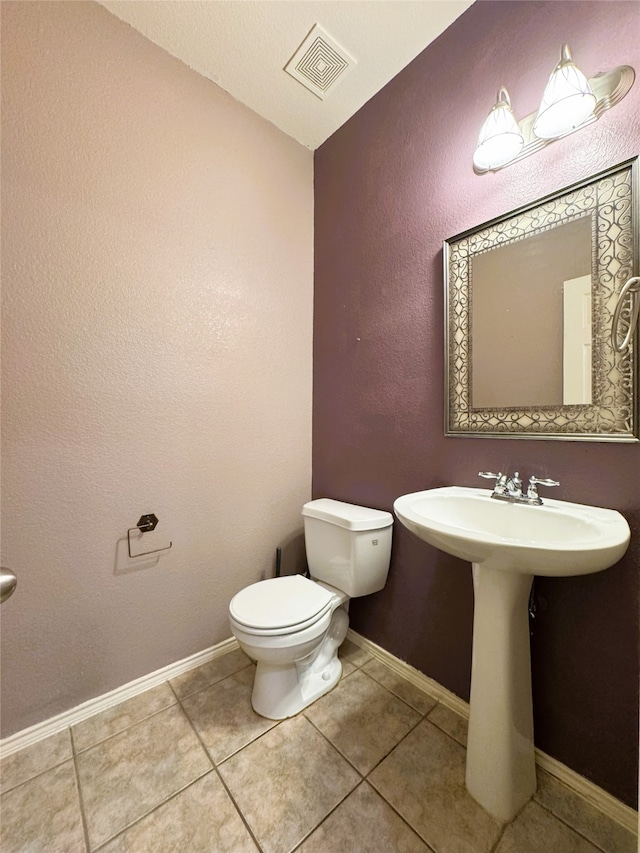 bathroom with baseboards, visible vents, a sink, tile patterned flooring, and toilet