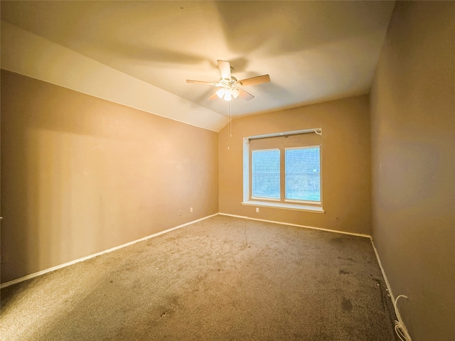 carpeted spare room with baseboards, ceiling fan, and vaulted ceiling