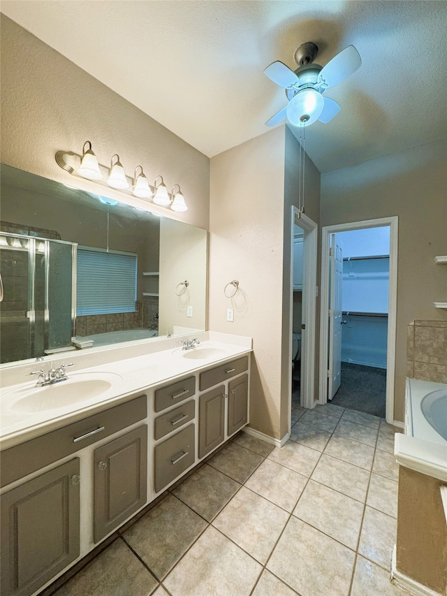 full bathroom featuring a sink, a stall shower, double vanity, and tile patterned flooring