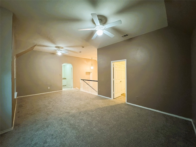 empty room featuring visible vents, baseboards, ceiling fan, carpet floors, and arched walkways