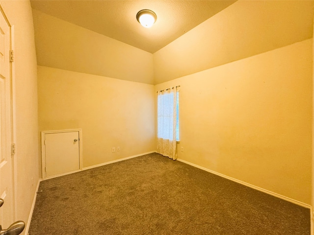 bonus room featuring baseboards, lofted ceiling, and dark colored carpet