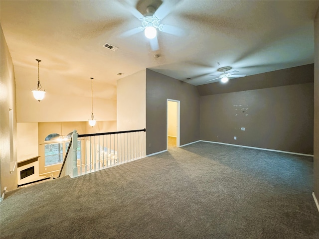 carpeted spare room with visible vents, a textured ceiling, lofted ceiling, and a ceiling fan