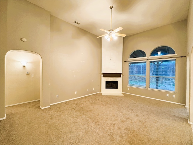 unfurnished living room with visible vents, a fireplace, a ceiling fan, and carpet floors