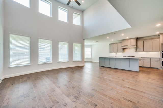 kitchen featuring open floor plan, light wood-style floors, and ceiling fan