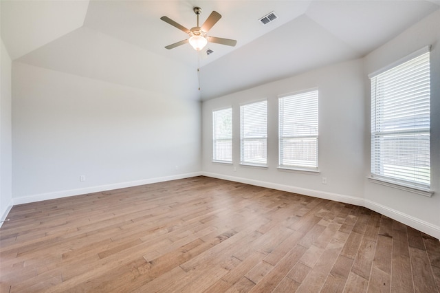 unfurnished room featuring visible vents, baseboards, vaulted ceiling, wood finished floors, and a ceiling fan